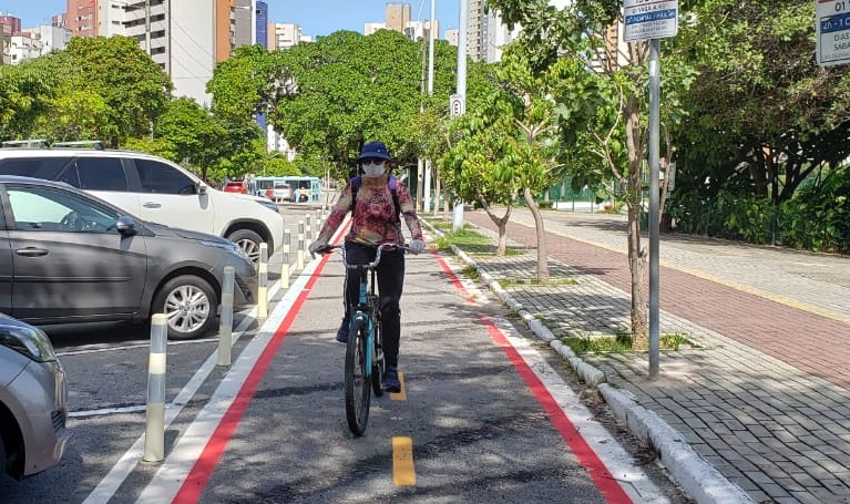 mulher anda de bicicleta numa ciflofaixa